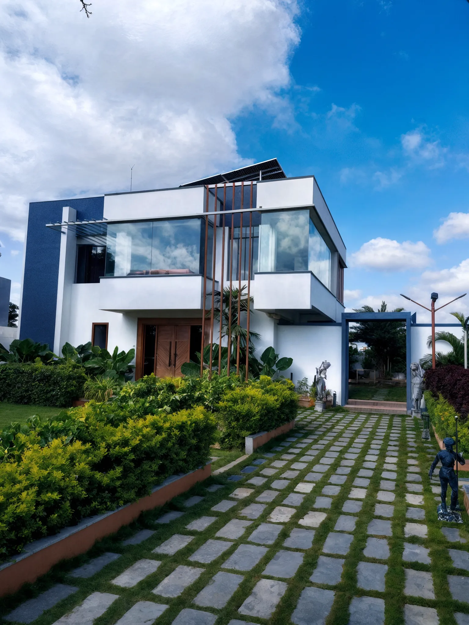 Auroville Farmstay in golden evening light, with its welcoming architecture and lawns
